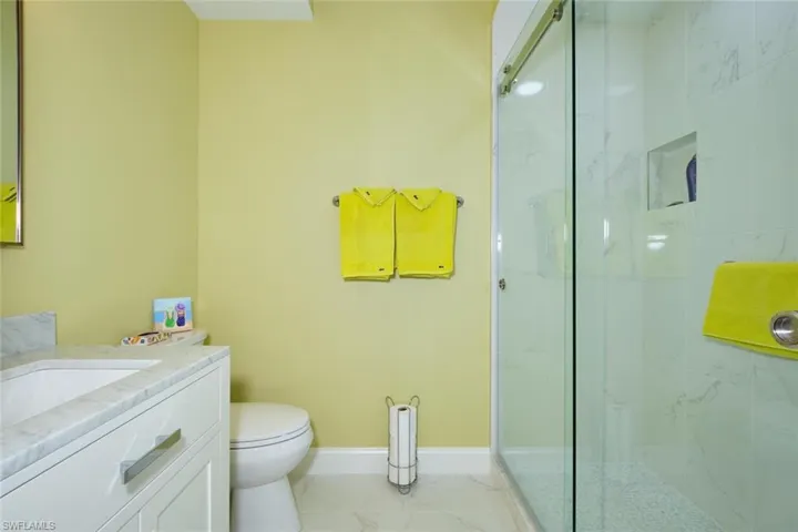 Full bath with baseboards, marble finish floor, and a marble finish shower
