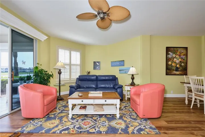 Living room with baseboards, wood finished floors, and a ceiling fan