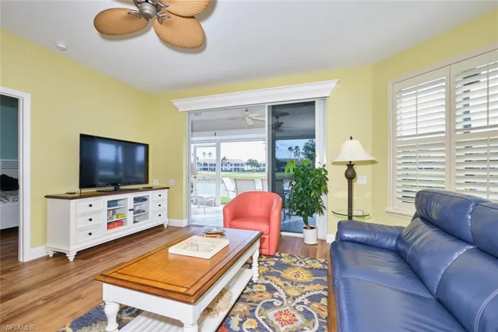 Living room with a ceiling fan, baseboards, and wood finished floors