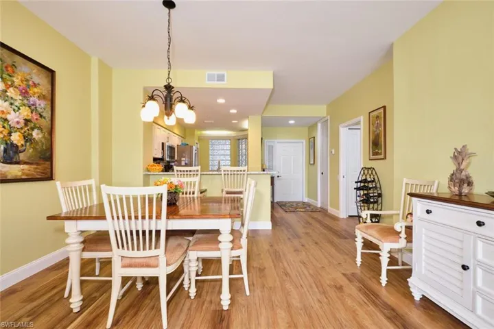 Dining space with an inviting chandelier, baseboards, light wood finished floors, and visible vents