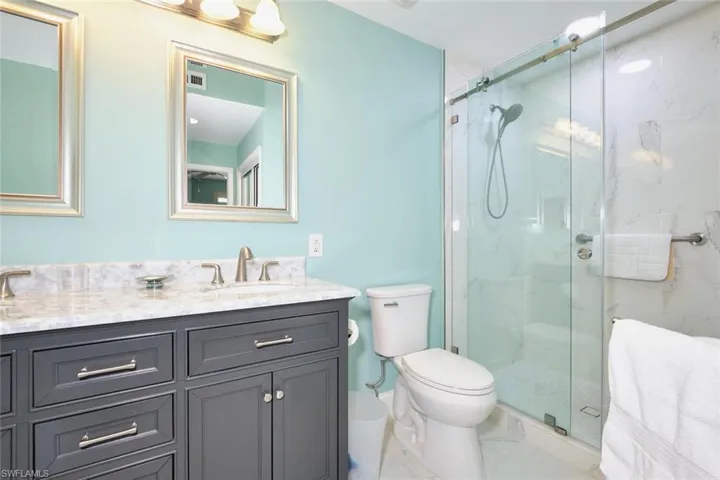Full bathroom featuring marble finish floor, toilet, and a marble finish shower