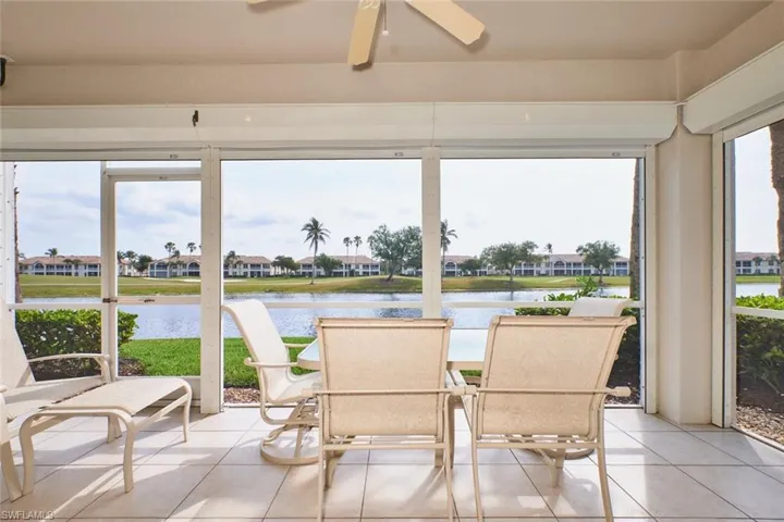 Sunroom / solarium with a water view, tile patterned floors, and a ceiling fan