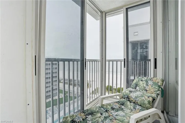 Balcony overlooks beach and pool