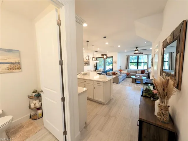 Kitchen featuring white cabinetry, open floor plan, hanging light fixtures, ceiling fan, and recessed lighting