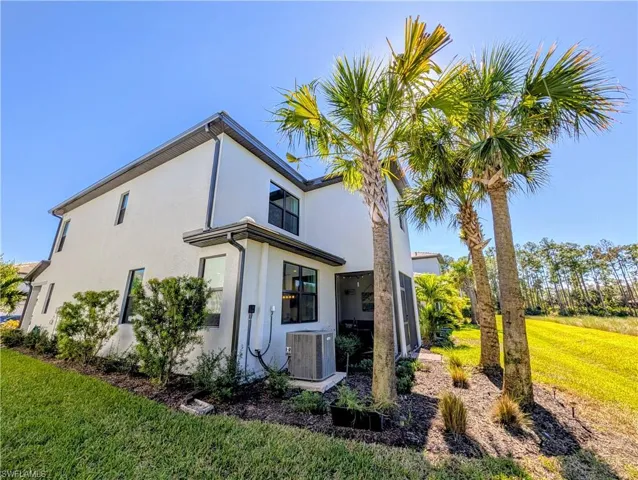 Rear view of property with a yard and stucco siding