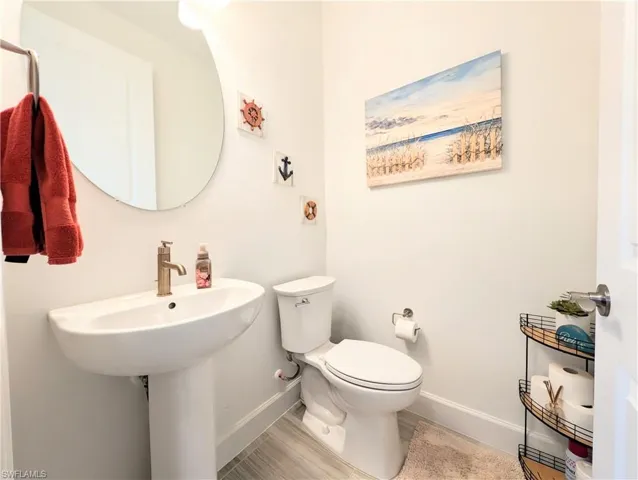 Half bath featuring baseboards and toilet