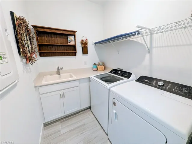 Laundry room featuring independent washer and dryer and cabinet space