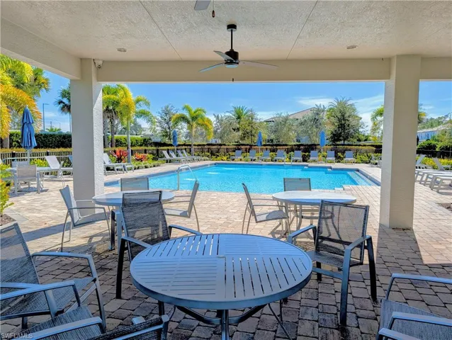 Community pool with a patio area and a ceiling fan