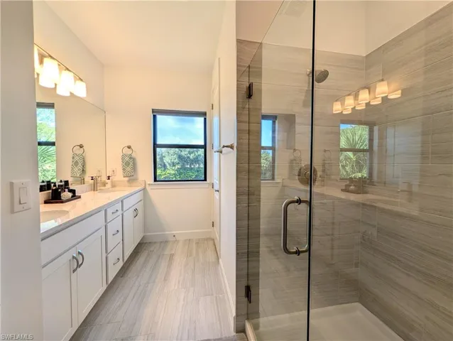 Bathroom with double vanity and a stall shower
