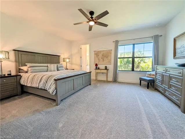 Bedroom with light carpet and a ceiling fan