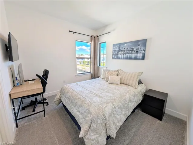 Bedroom featuring an office area and carpet floors