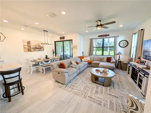 Living area with recessed lighting, light wood-style flooring, and a ceiling fan