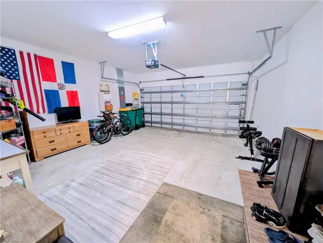 Garage featuring electric panel and a garage door opener