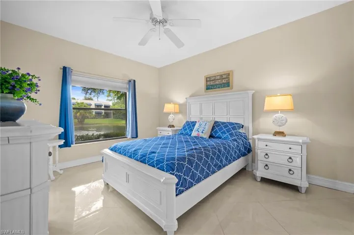Bedroom featuring light tile patterned floors, ceiling fan, and a water view