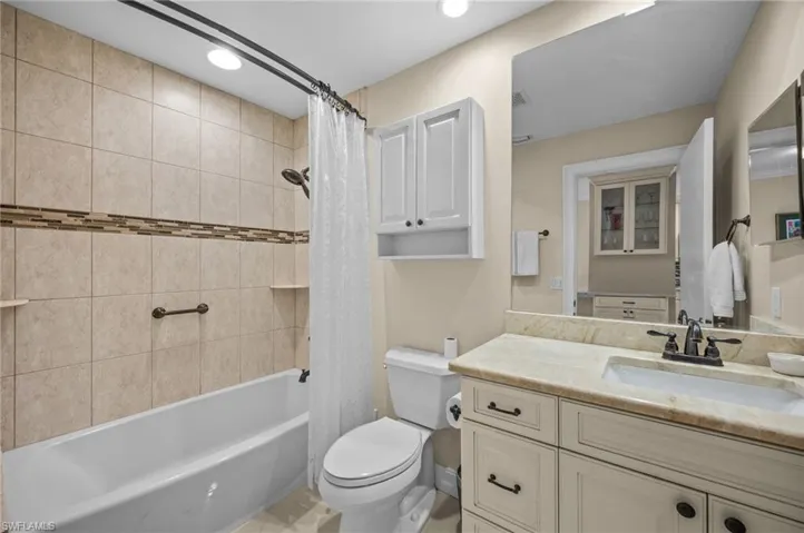 Full bathroom with shower / bath combo, vanity, and recessed lighting