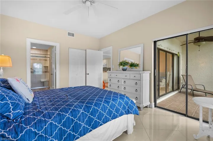Tiled bedroom with a closet, ceiling fan, and connected bathroom