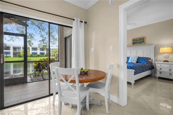 Dining area featuring a water view, crown molding, and light tile patterned floors