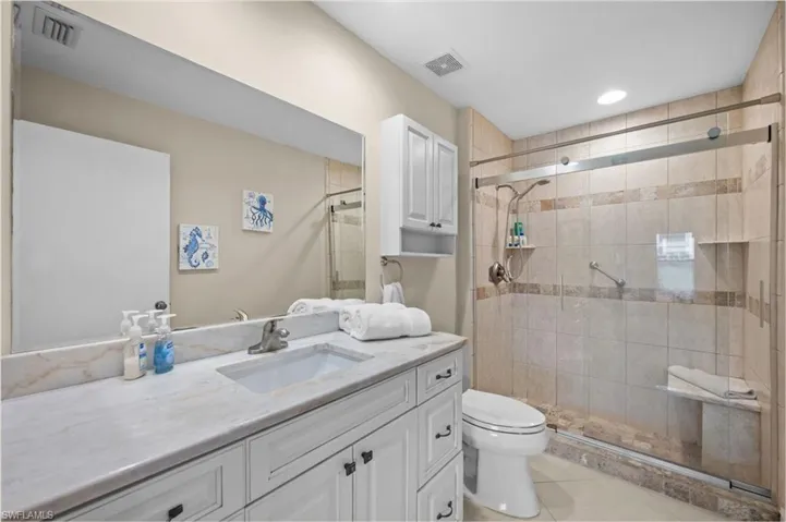 Bathroom with vanity, a shower stall, and light tile patterned flooring