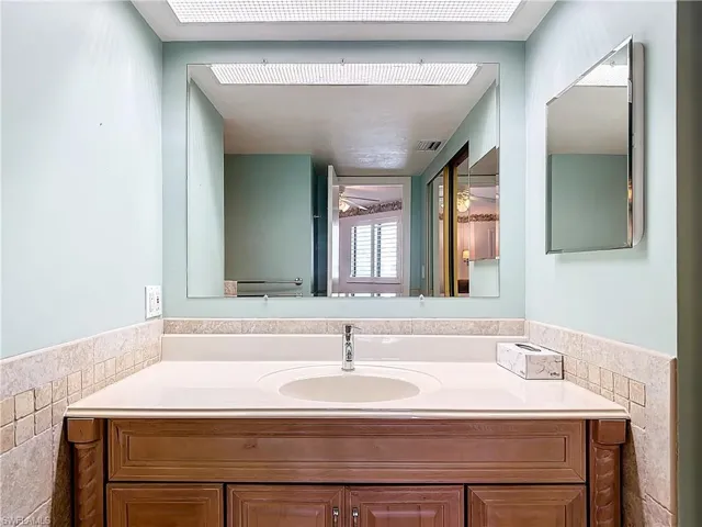 Bathroom with tile walls, vanity, and ceiling fan