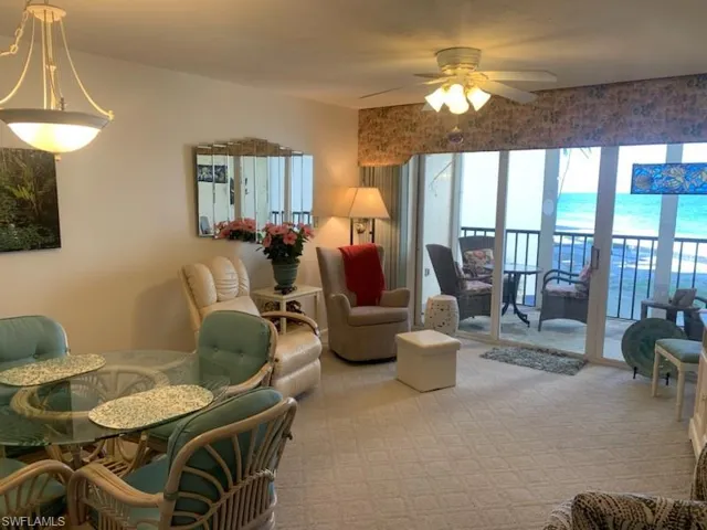 Living room featuring light carpet and ceiling fan