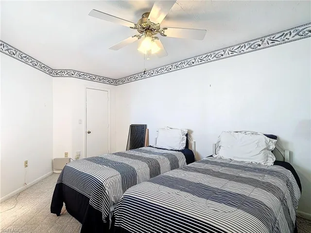 Bedroom with light colored carpet and ceiling fan