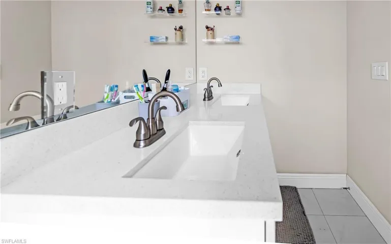 Double vanity featuring integrated rectangular sinks, white stone-finish countertop, and brushed nickel faucets