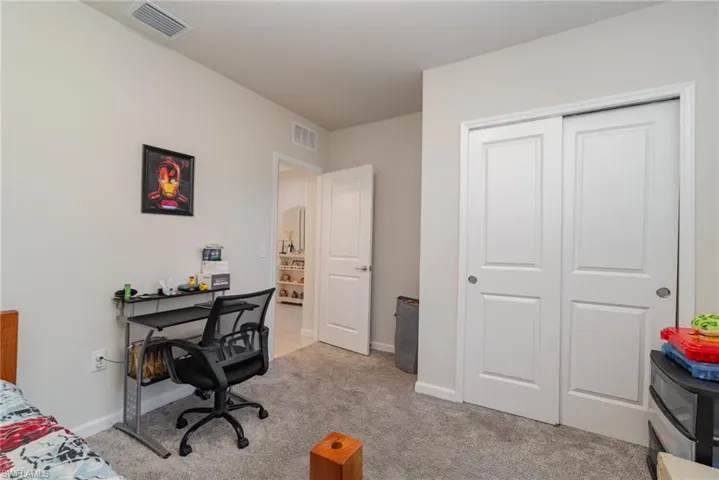 Bedroom with light carpet and a closet