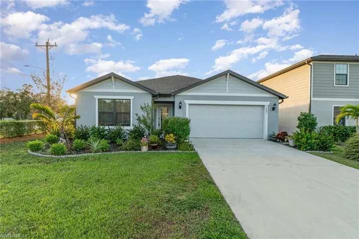 View of front of property with a front yard and a garage