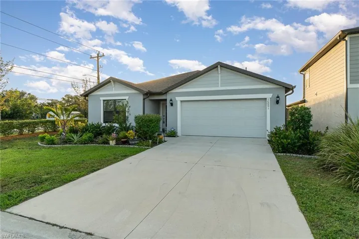 View of front facade featuring a garage and a front lawn