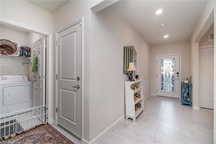 Tiled entryway featuring washer / dryer