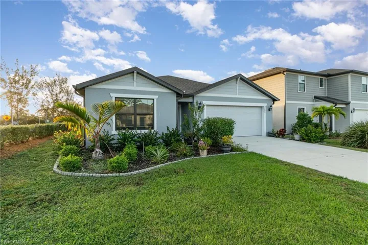 View of front of property with a front yard and a garage