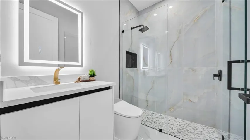 Full bathroom featuring vanity and a marble finish shower