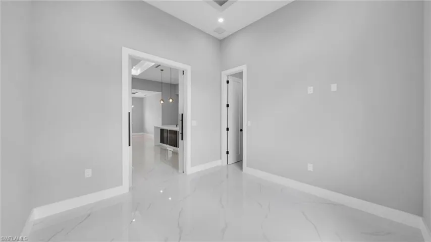 Empty room with light marble finish flooring and recessed lighting