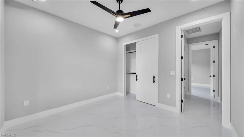 Unfurnished bedroom with light marble finish flooring, a closet, recessed lighting, and ceiling fan