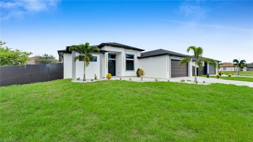 View of front facade featuring a garage, stucco siding, and concrete driveway