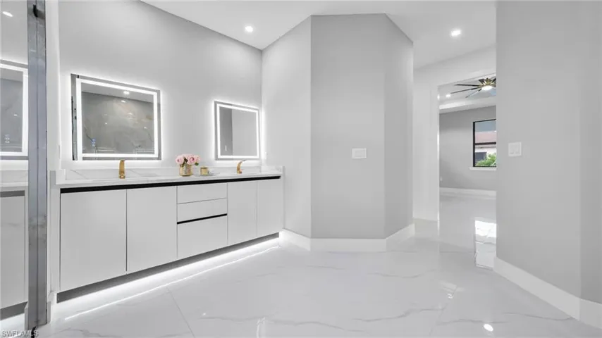 Bathroom with light marble finish floors, double vanity, recessed lighting, and a ceiling fan