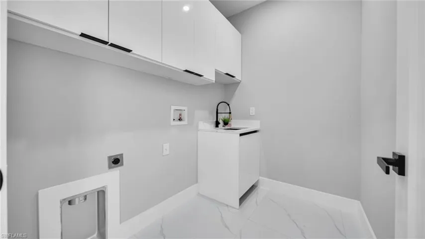 Laundry room featuring hookup for a washing machine, hookup for an electric dryer, marble finish floors, and cabinet space