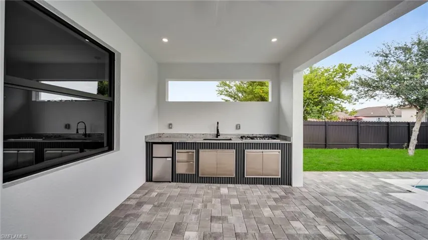 View of patio with exterior kitchen and a sink