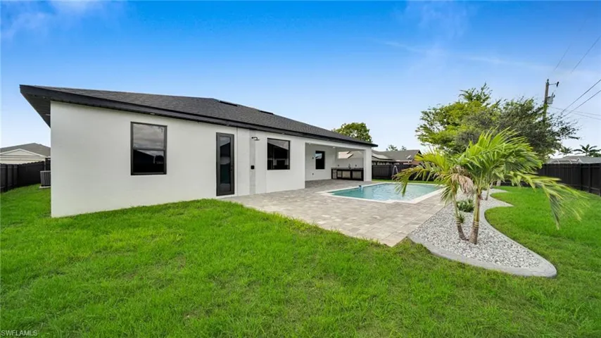 Back of property with a patio area, a fenced backyard, stucco siding, and roof with shingles