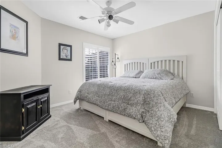 Carpeted bedroom featuring ceiling fan