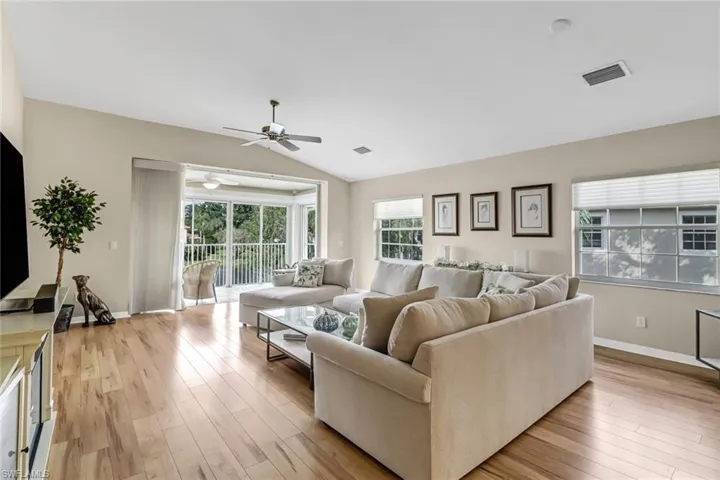 Living room with light wood-type flooring, lofted ceiling, and ceiling fan