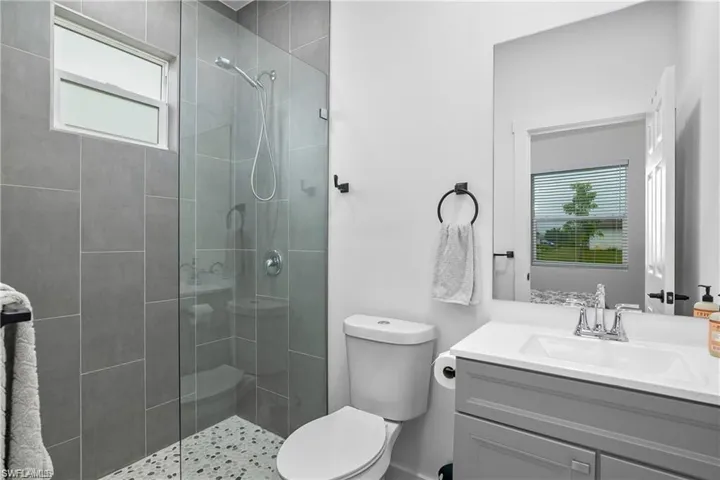 Full bath featuring a stall shower and vanity