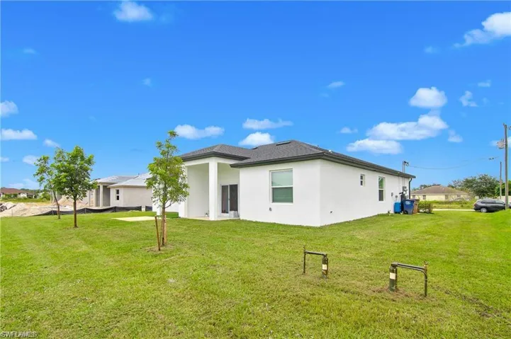 Back of property featuring a yard and stucco siding