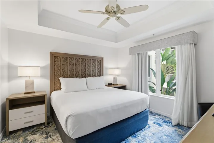 Bedroom featuring a tray ceiling, ornamental molding, and ceiling fan