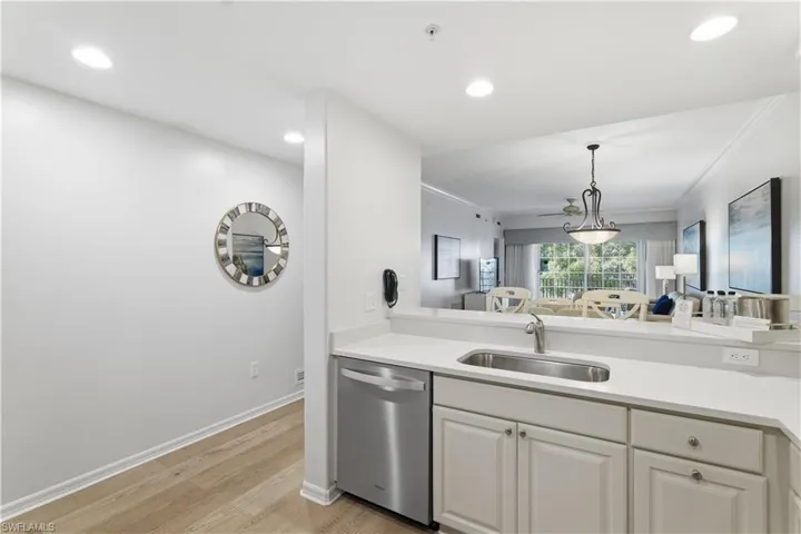 Kitchen featuring stainless steel dishwasher, light wood-type flooring, decorative light fixtures, open floor plan, and recessed lighting