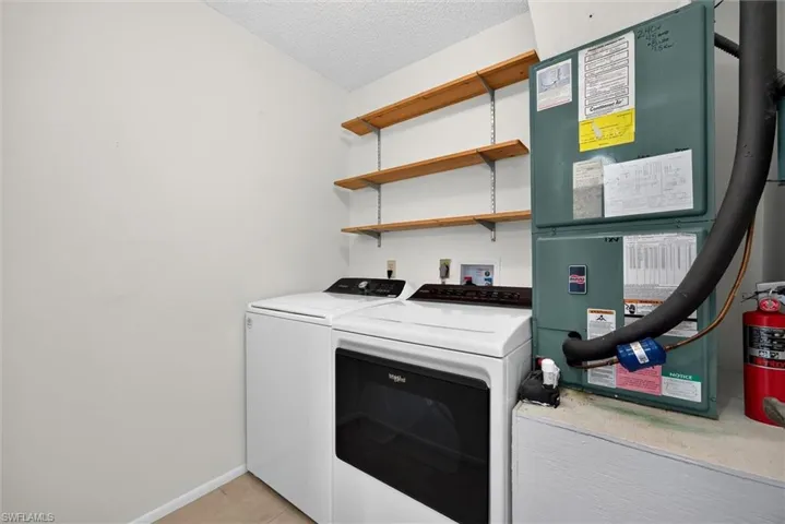 Utility space featuring built-in wood shelving and a high-efficiency HVAC system