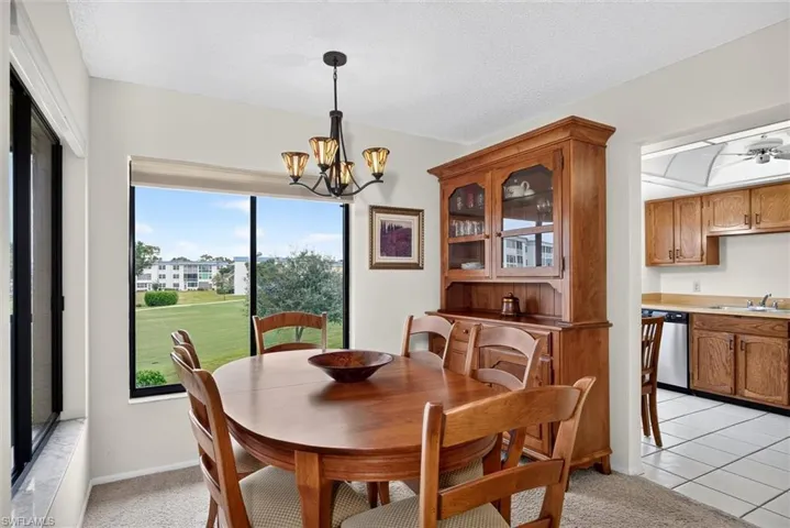 Dining area featuring large sliding glass doors, a five-arm multi-light chandelier, and a built-in wood cabinet