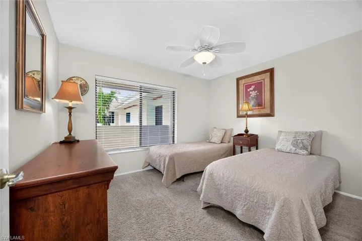 Neutral-toned interior featuring wall-to-wall carpeting, a multi-blade ceiling fan with integrated lighting, and a large horizontal window with horizontal blinds