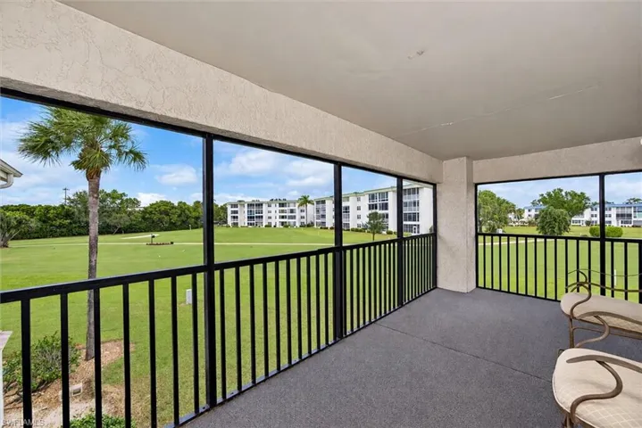 Screened-in balcony featuring stucco ceiling, textured wall finish, and metal railing