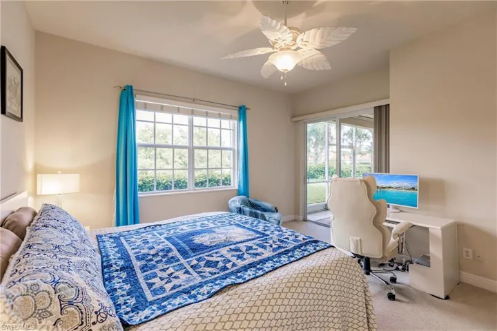 Bedroom with ceiling fan, carpet floors, and multiple windows